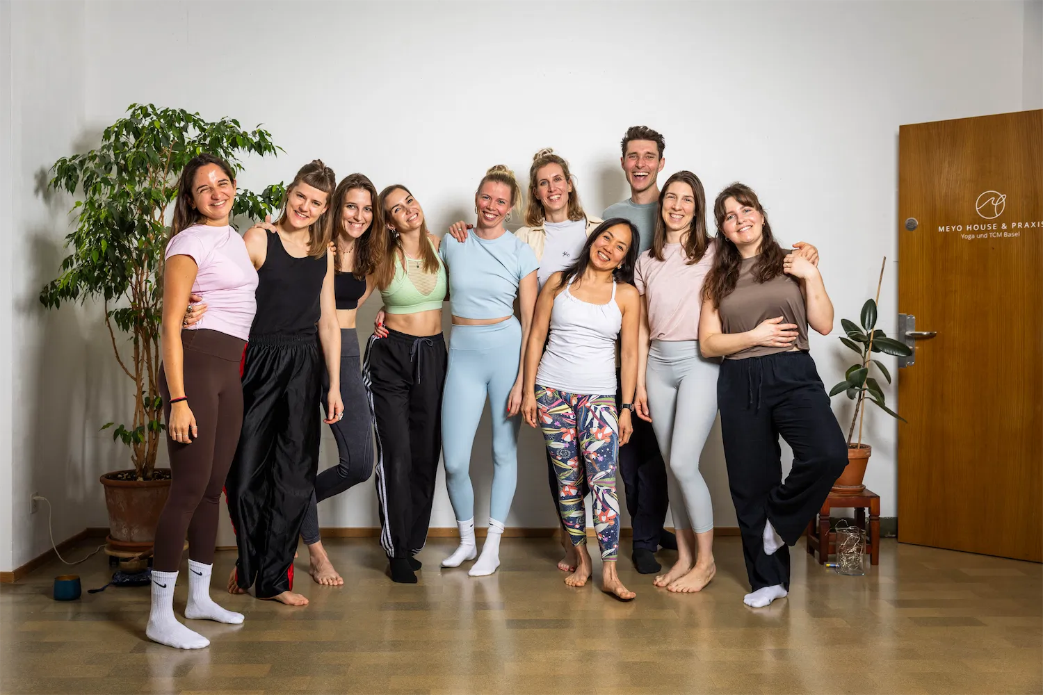 woman in white tank top and black leggings doing yoga during daytime