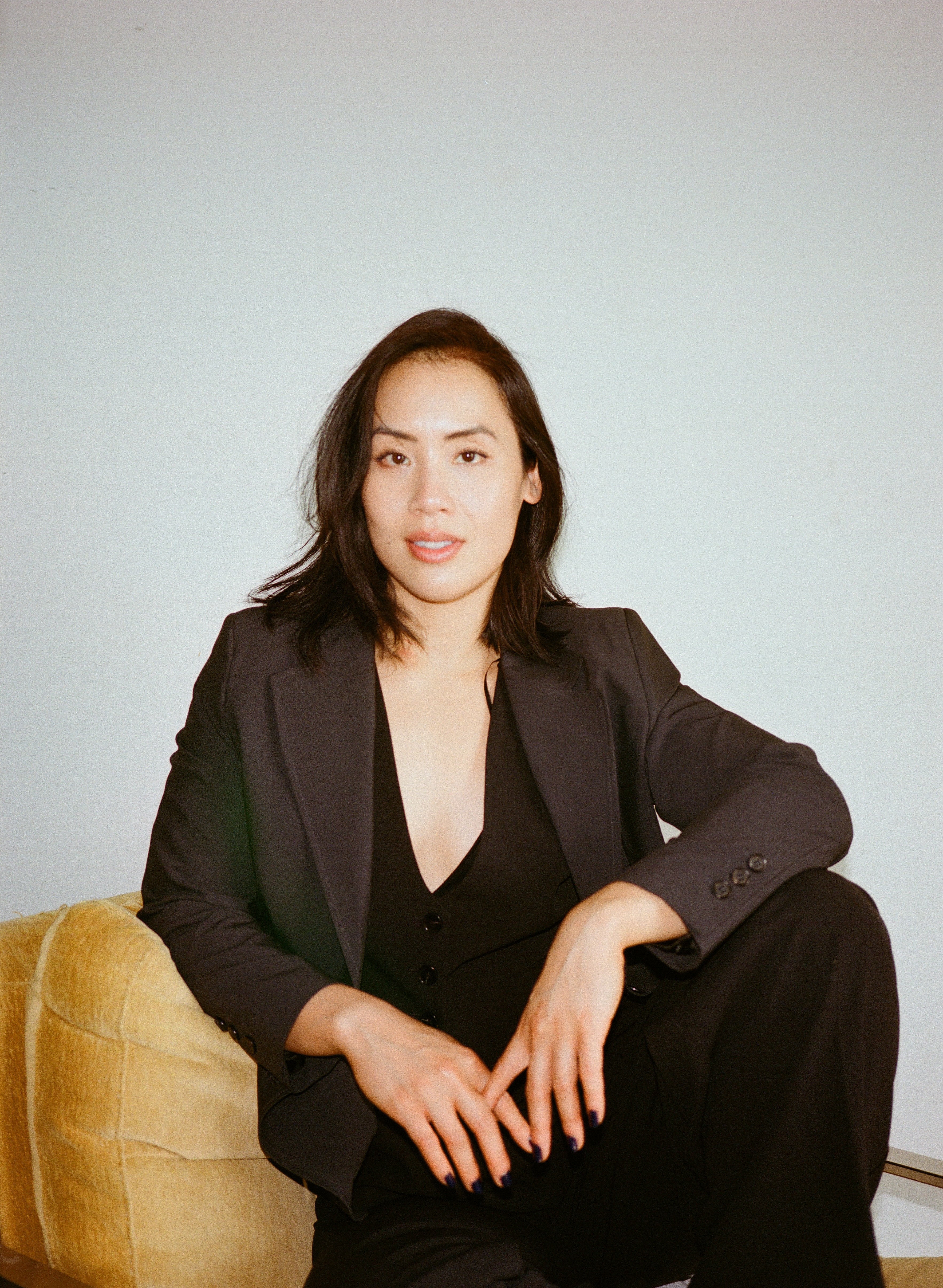 Young woman in casual clothing posing against a white background.