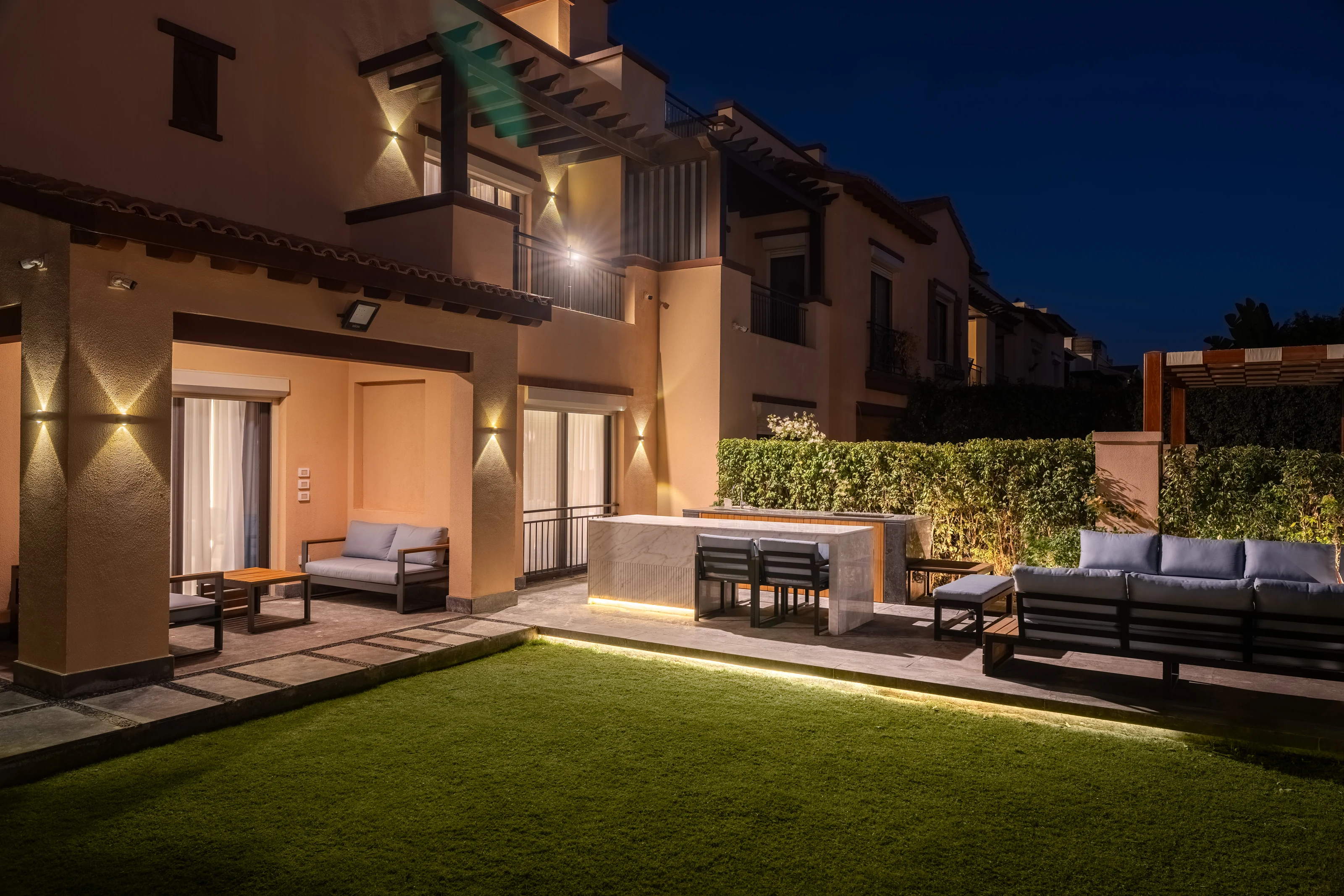 Landscaped outdoor lounge at Mivida Twin Villa at night.