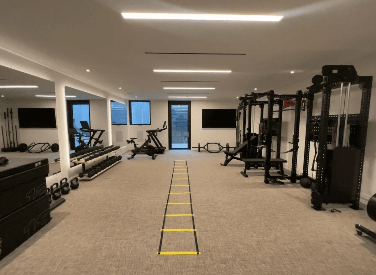Completed home gym build in an Ottawa residence featuring a full training layout with cardio equipment, free weights, functional training space, and clean, modern finishes