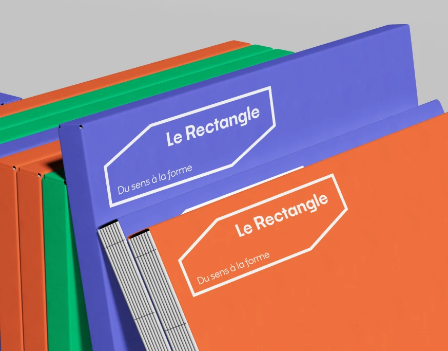 Mockup classeurs Le Rectangle déclinés dans les trois couleurs de la palette — bleu, vert, orange avec logo blanc, application du système graphique modulaire, Tartelette Concept graphiste Toulouse
