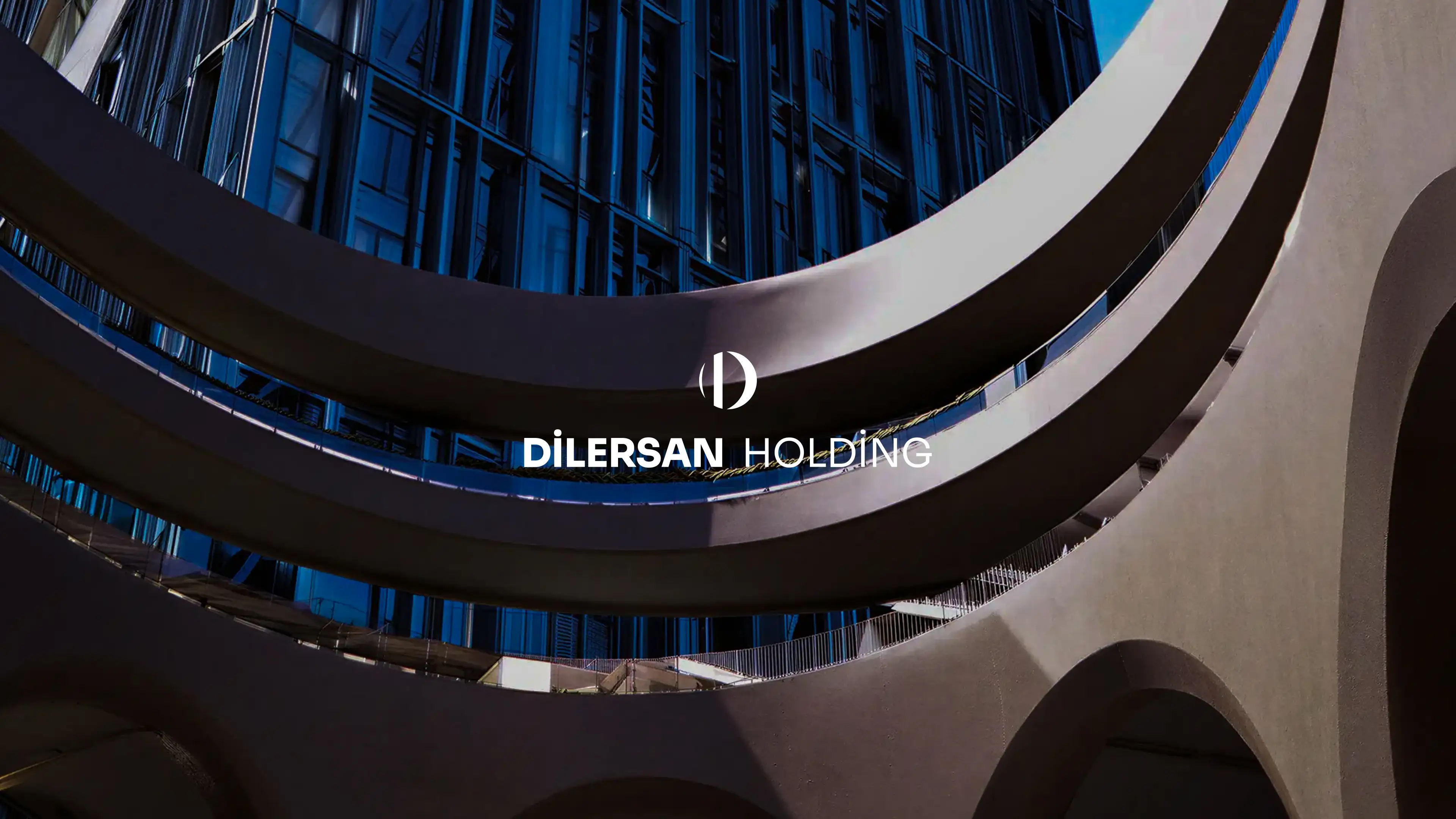 Official Dilersan Holding website hero image featuring cinematic blue-lit modern architecture and the white corporate wordmark.