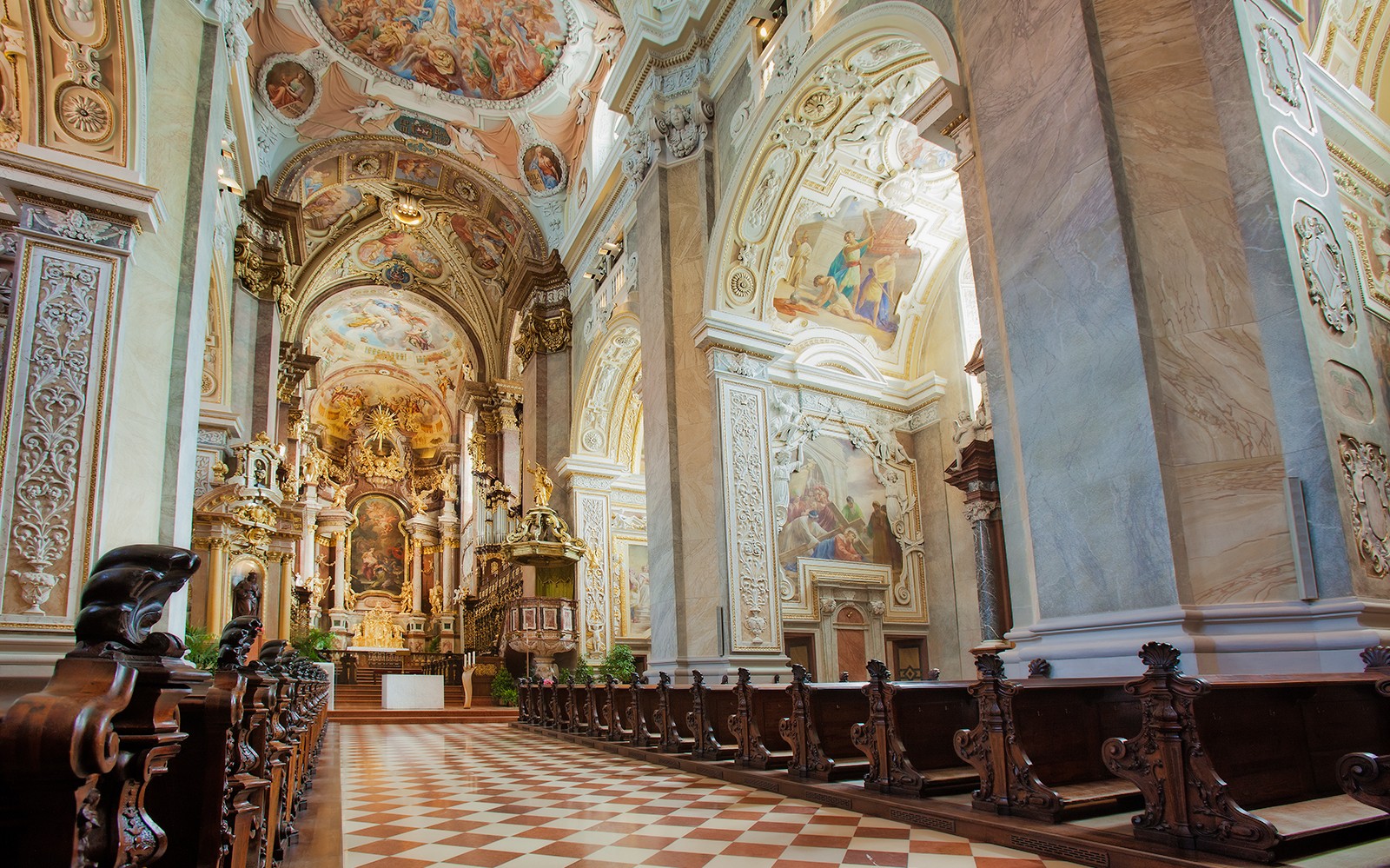 Interior of Klosterneuburg Monastery with ornate frescoes and wooden pews, Austria.