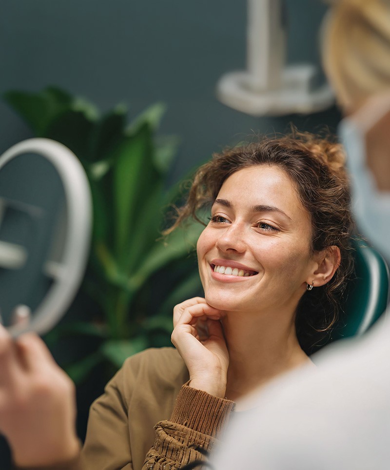 woman looking in a mirror and smiling