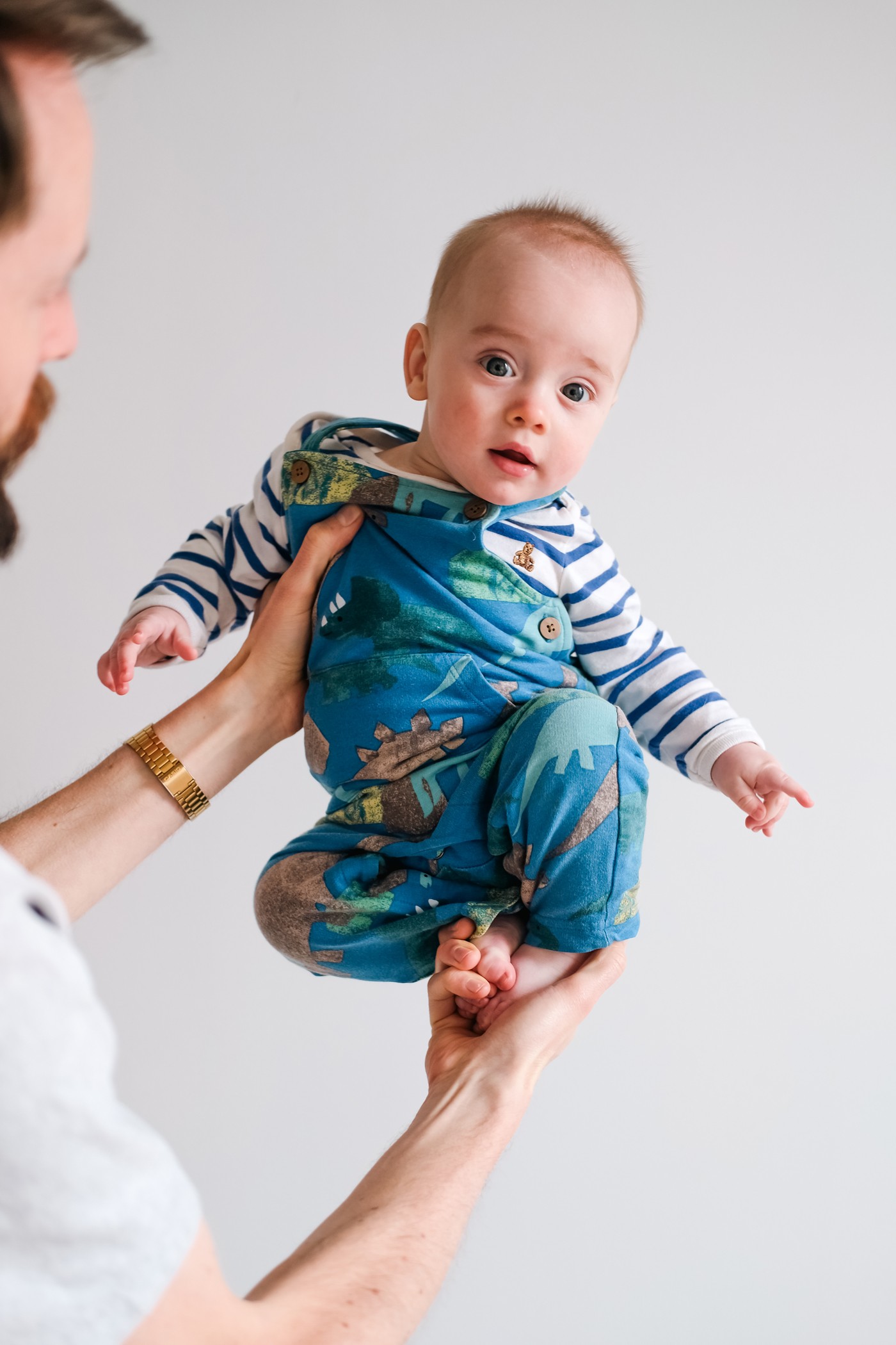 father-lifting-baby-studio-portrait-white-background-new-york