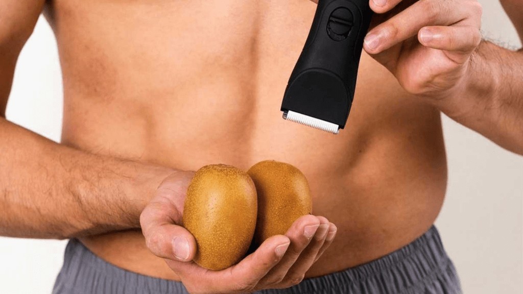This image depicts a man holding two fruits and a Nateskin shaver, symbolising smooth male grooming as promoted by the brand.