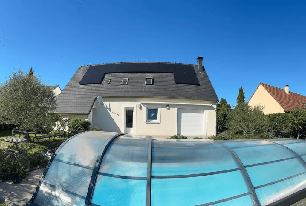 Photo d'une maison à Saint-Doulchard équipée de panneaux photovoltaïques dont l'installation a été faite par Solarock. On voit également au premier plan une piscine