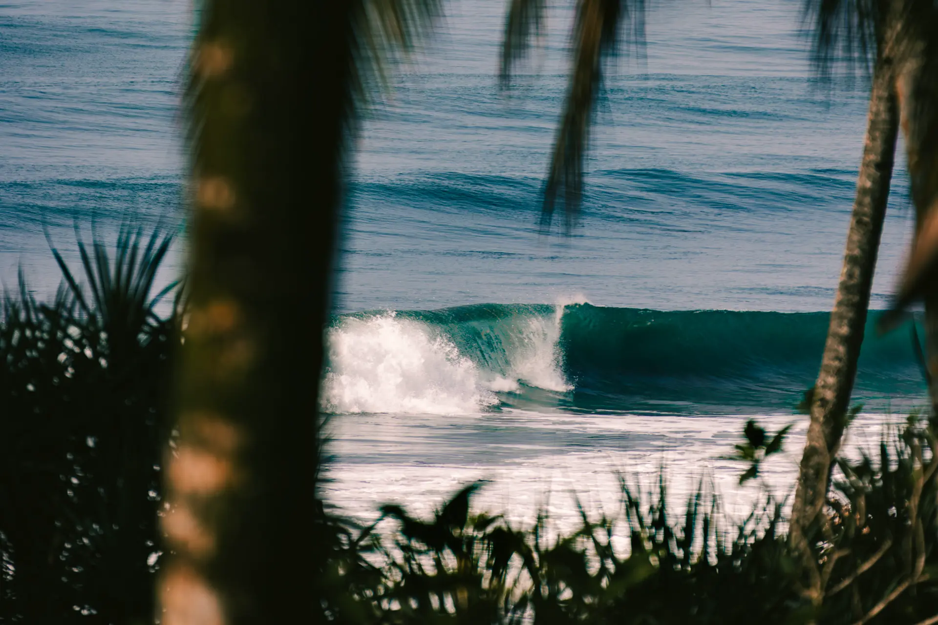 Wellen brechen am tropischen Sandstrand von Bali – Naturkulisse des Kelapa Retreat & Spa Resorts