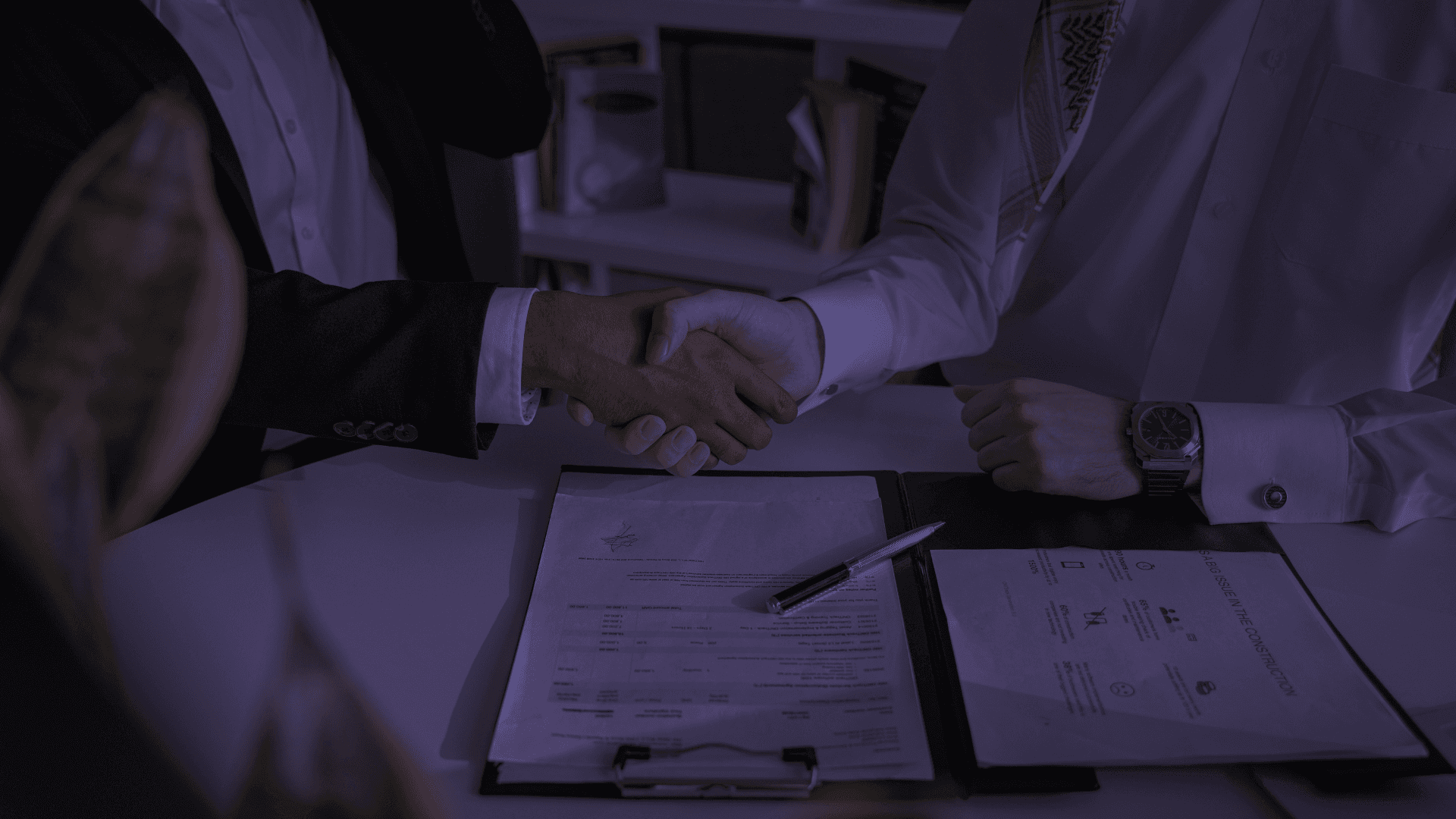 Person working on laptop at a wooden desk.