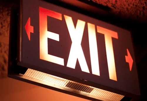Illuminated red exit sign above an emergency light