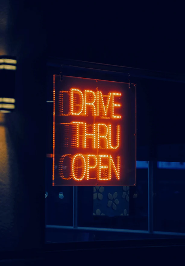 Illuminated neon drive thru open sign at night