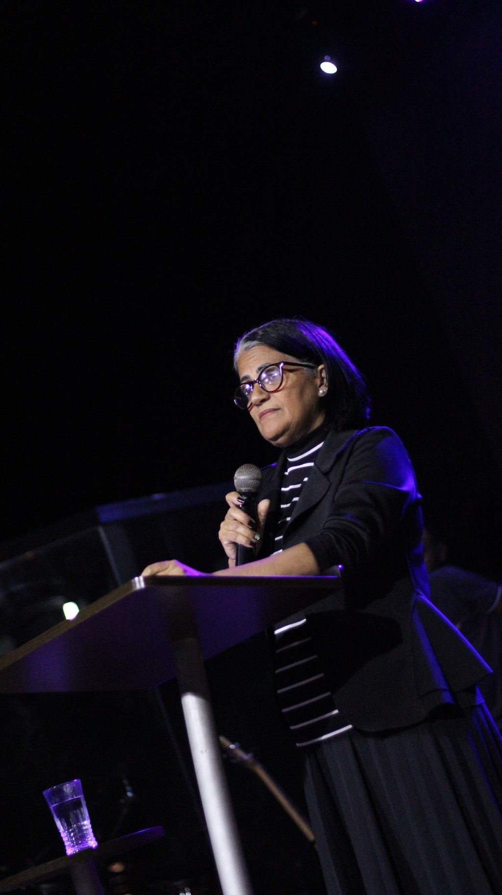 man in pink dress shirt wearing black sunglasses sitting on gray couch