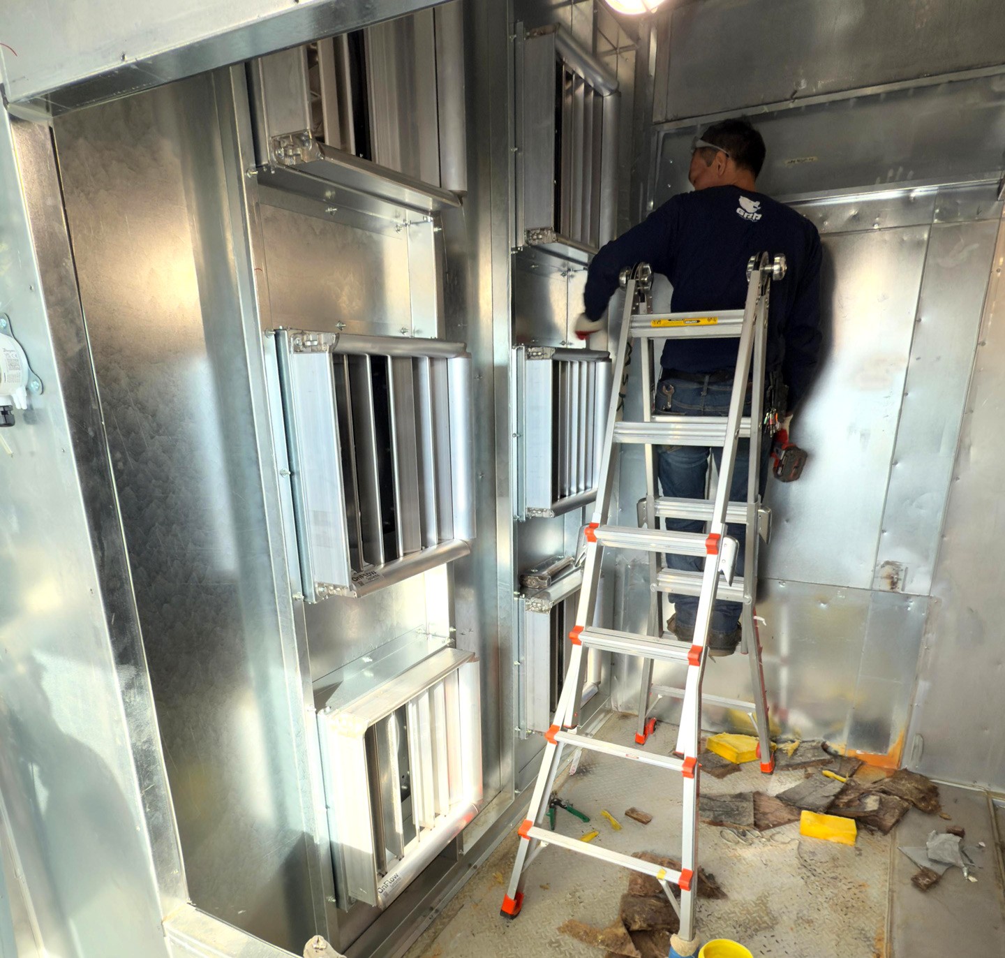 Technician installing a modular EC fan array inside a healthcare air handling unit during a live retrofit in New York City.