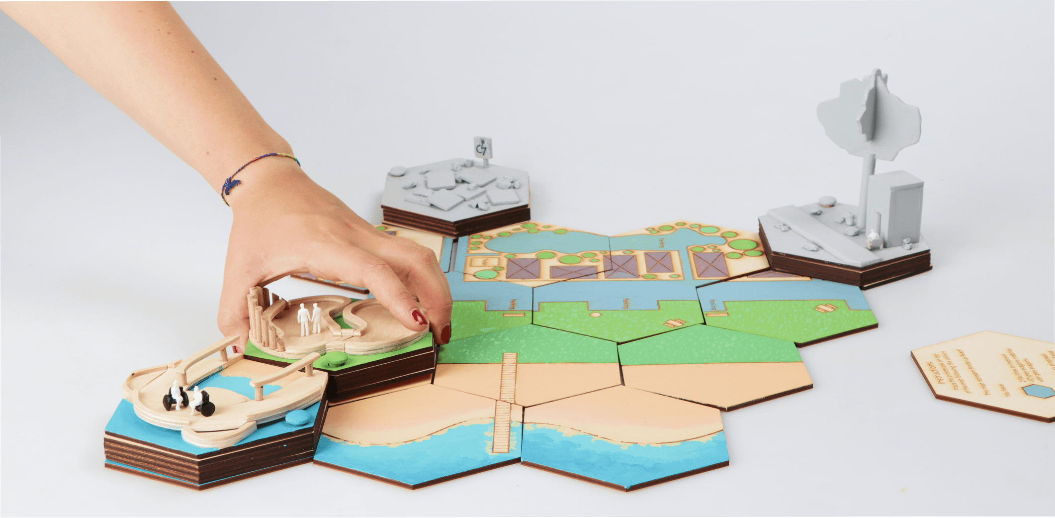 Hand holding waffle cone with three scoops of colorful pastel ice cream