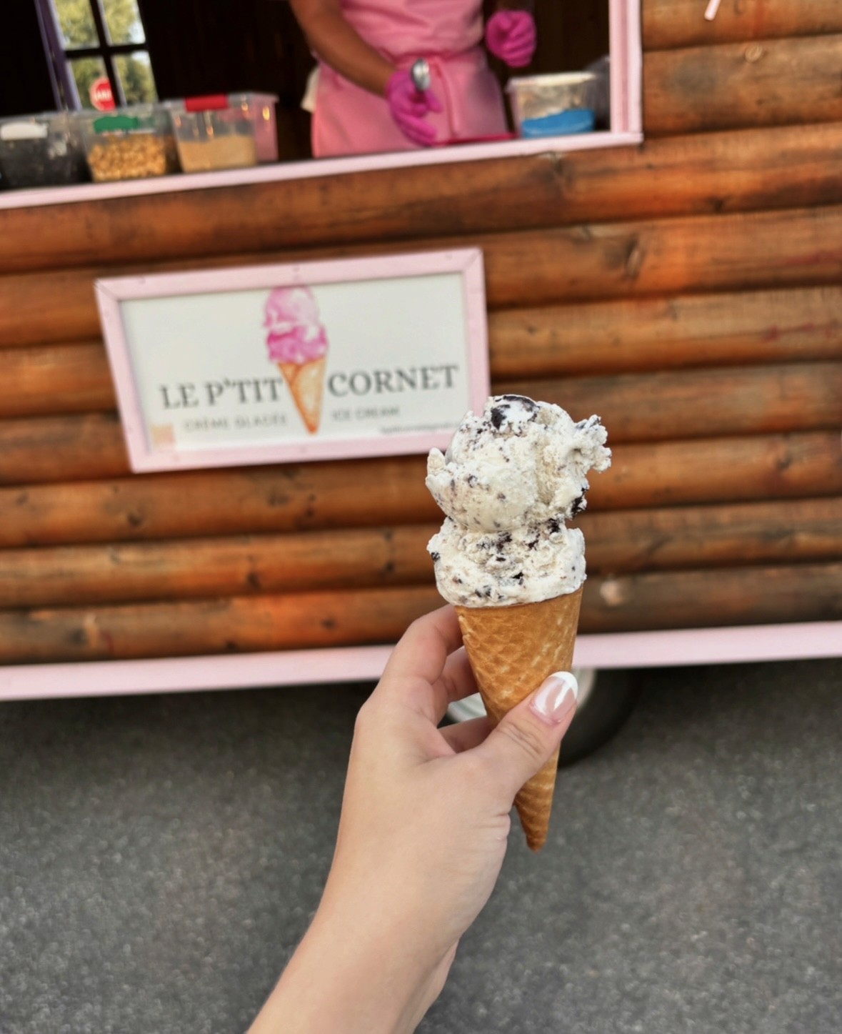 Sugar cone filled with cookies and creame ice cream, photographed in front of the Le P'tit Cornet ice cream trailer