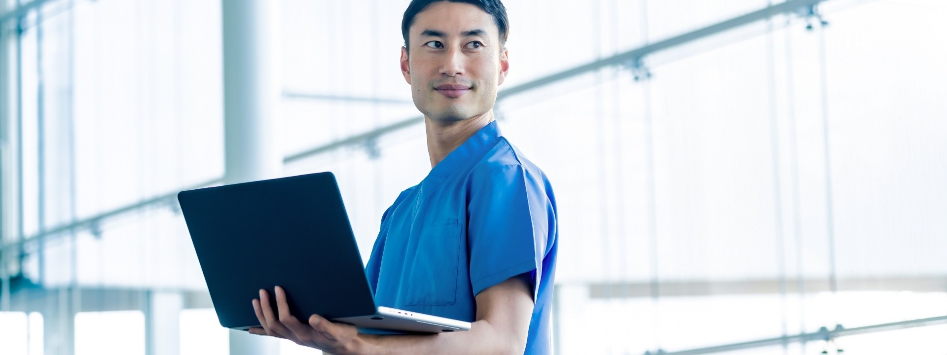 ノートパソコンを持つ医療従事者