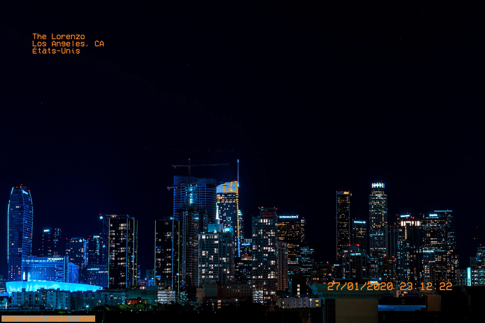 Vue nocturne de la skyline de Los Angeles, avec des gratte-ciels illuminés en hommage à Kobe Bryant depuis The Lorenzo.