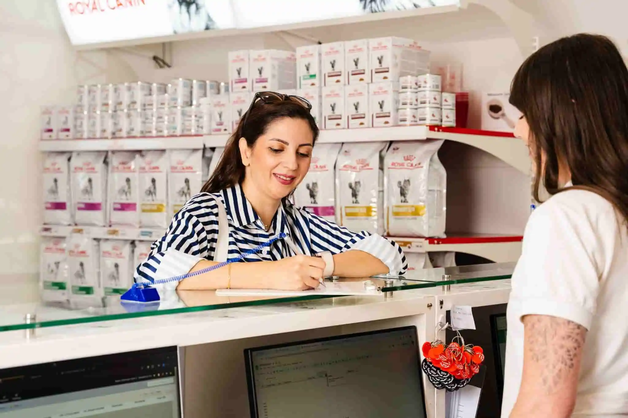 A pet owner picks up her cat’s medications at our vet pharmacy in Dubai.
