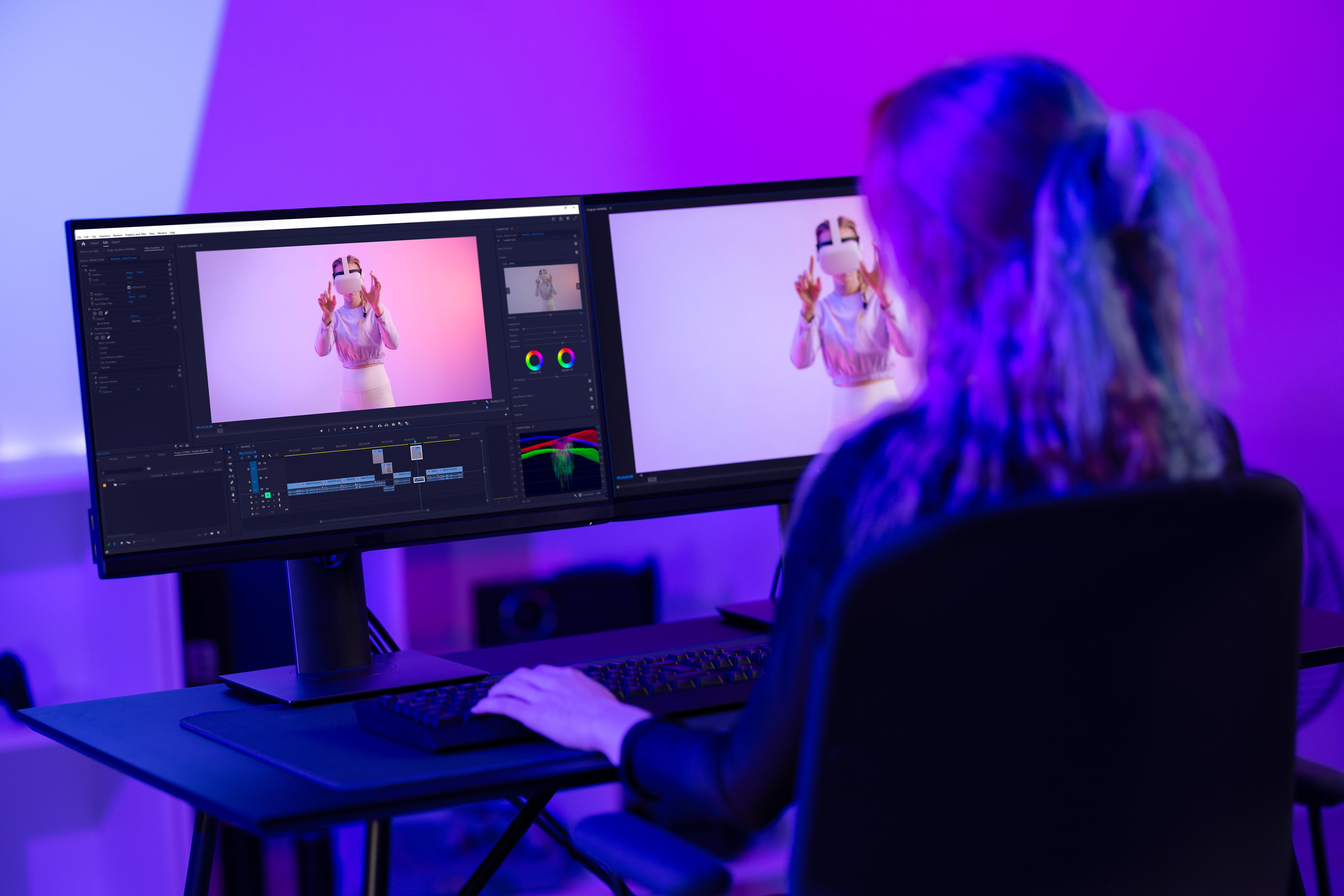 Female video editor working on VR content using dual monitors in a creative studio setup