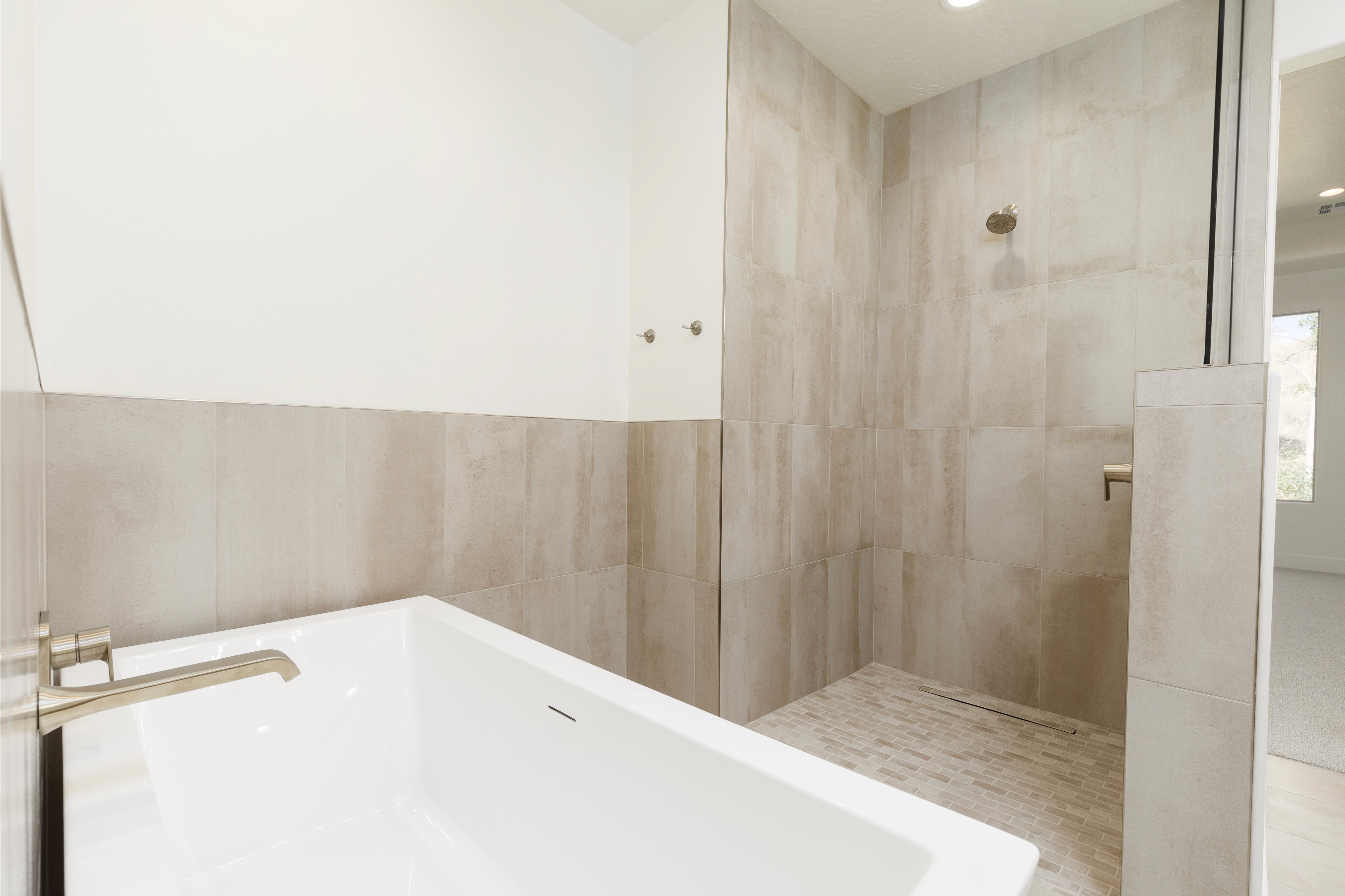 Primary bathroom shower in Mountain View’s Cove featuring tiled walls and modern fixtures in a Hurricane, Utah custom home.