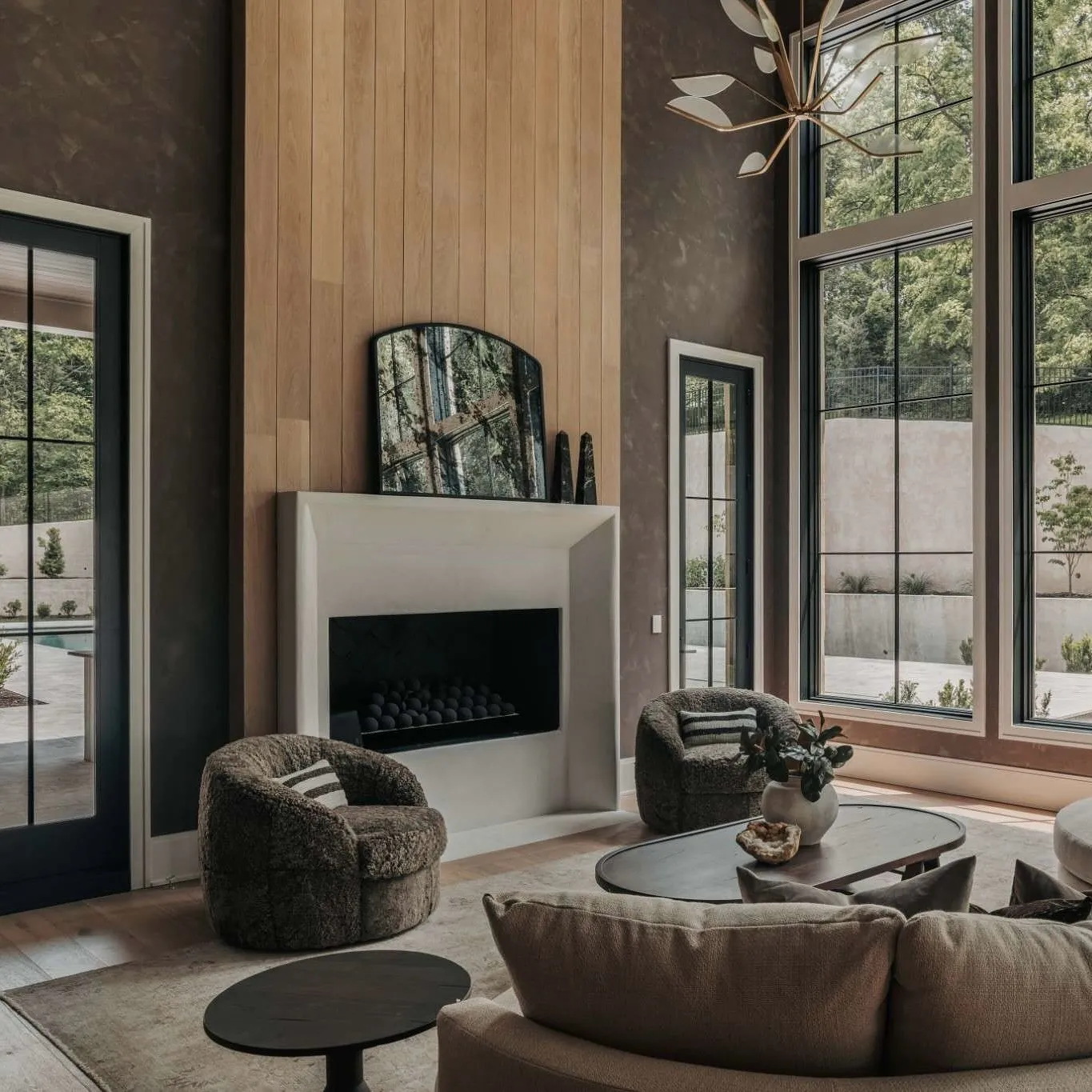 A cozy living room with a fireplace, large windows, and comfortable seating.