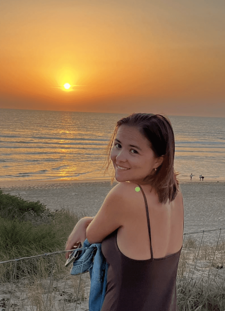 justine de gennes in front of a sunset on the beach