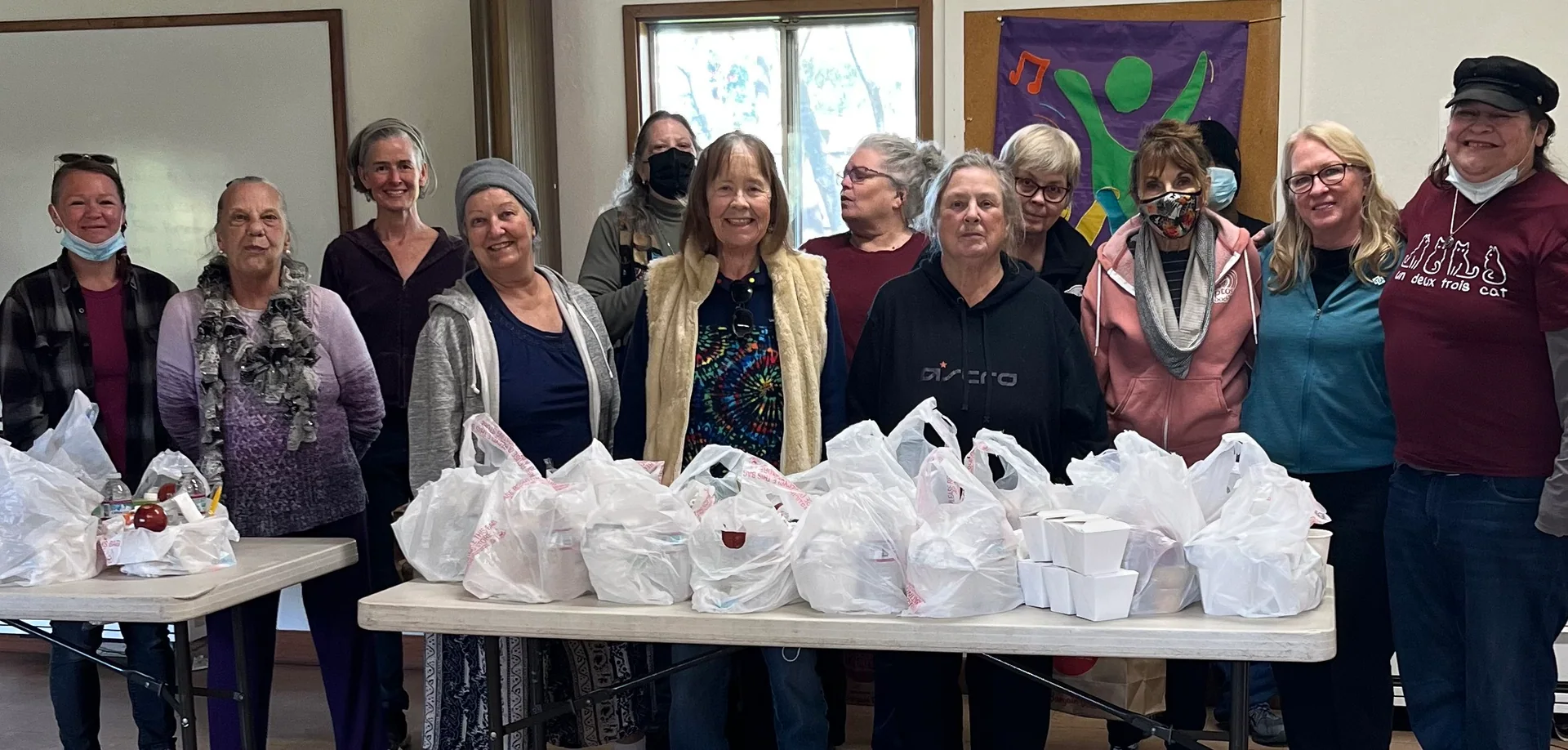 Team Just Us gathered behind a table of meals prepared to share