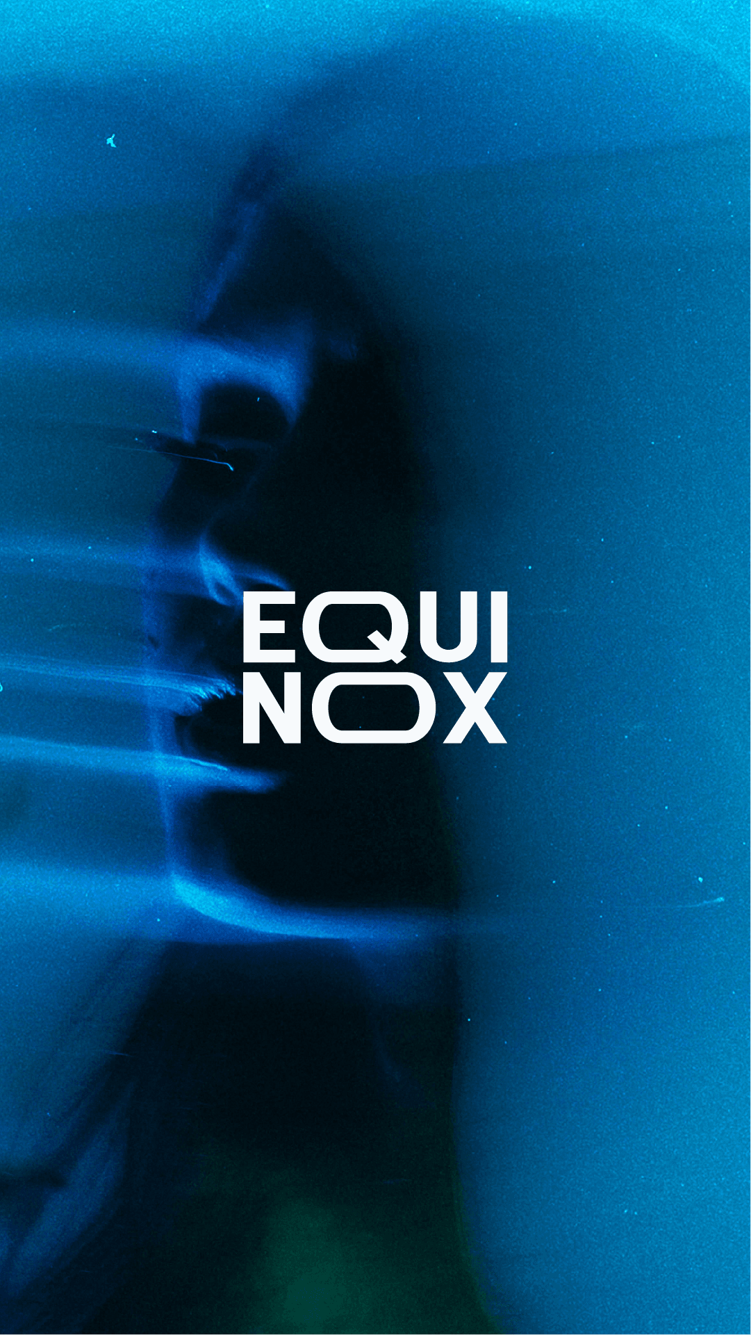 A laptop on the sand showing a person with a straw hat, surrounded by shells.