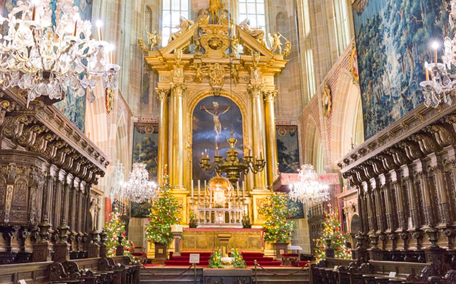 Interieur van de Wawel-kathedraal met een rijk versierd altaar en kroonluchters, rondleiding door Krakau.