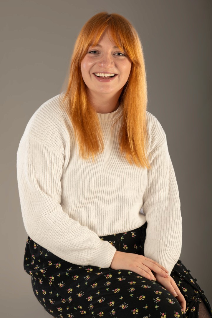 A woman with red hair having her portrait taken. 