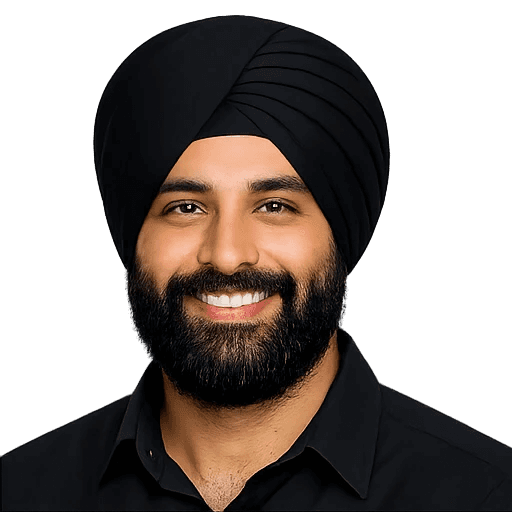 Portrait of a smiling man wearing a turban and black shirt against a neutral background.