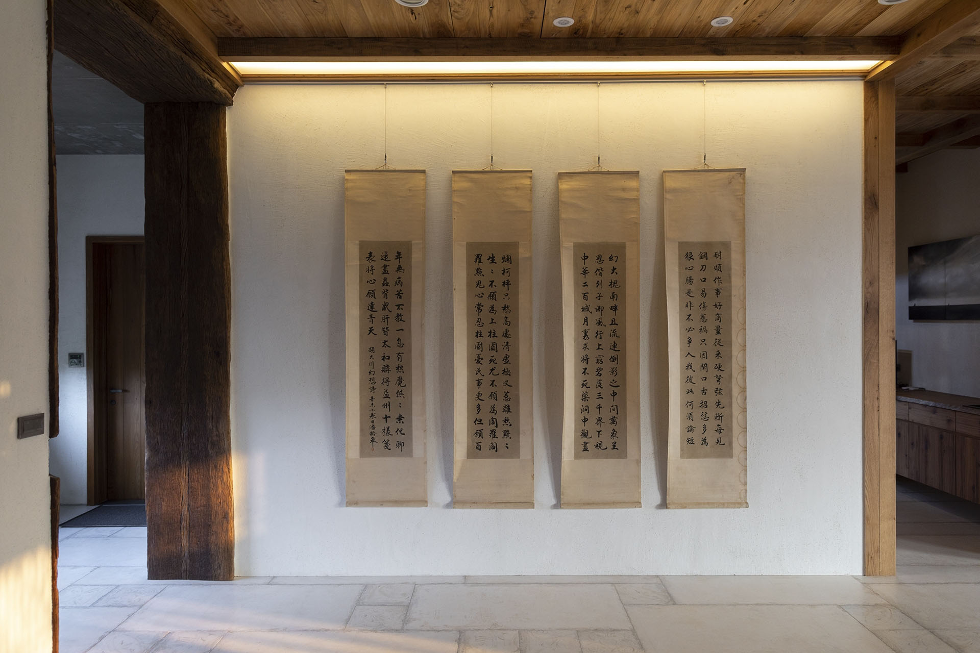 四幅直式書法掛軸整齊排列於牆上，配以木樑天花與間接照明營造文化氣息