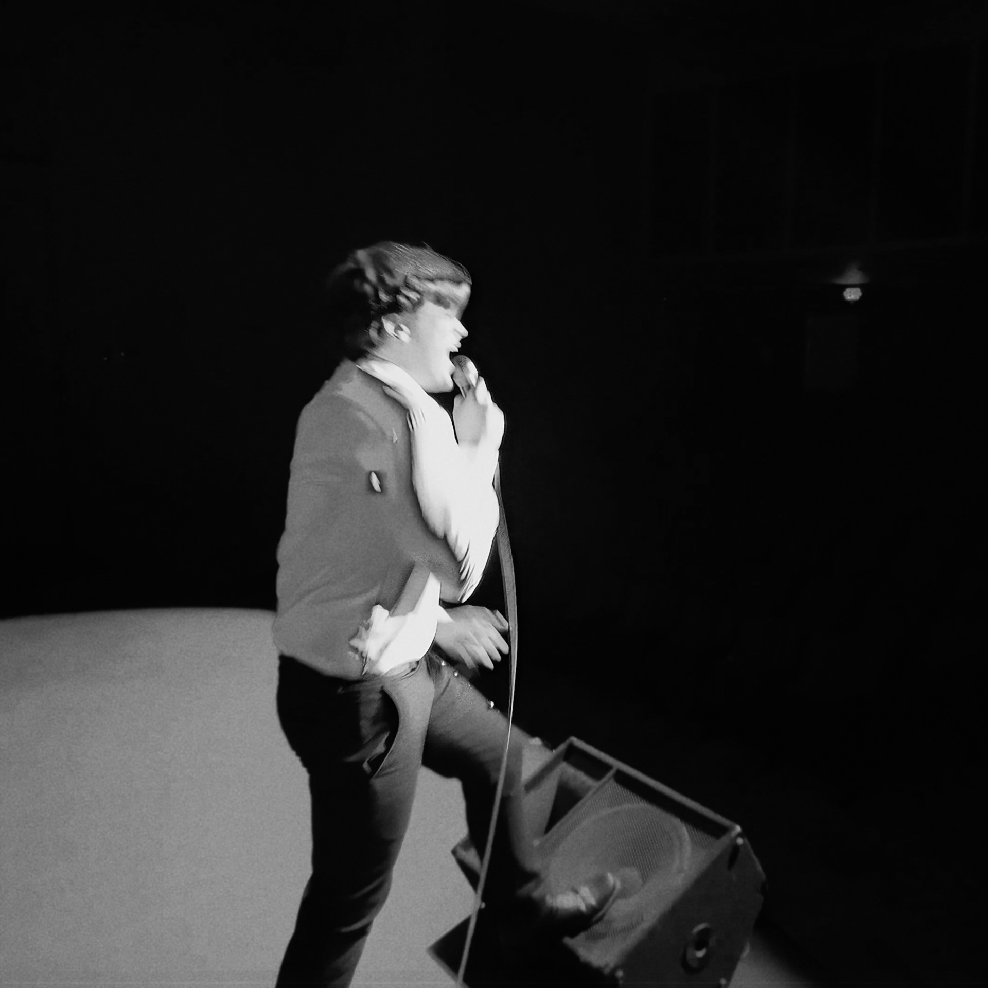 Performer under spotlight on dark stage