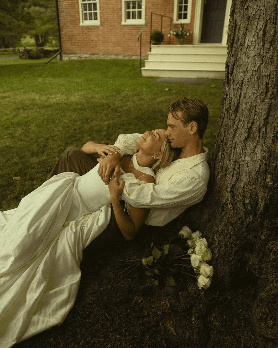 A serene and elegant spa space with wooden reclining chairs and white cushions. Golden sunlight filters through a cascading water feature, creating a peaceful atmosphere. Tropical plants and candles add to the relaxing ambiance.