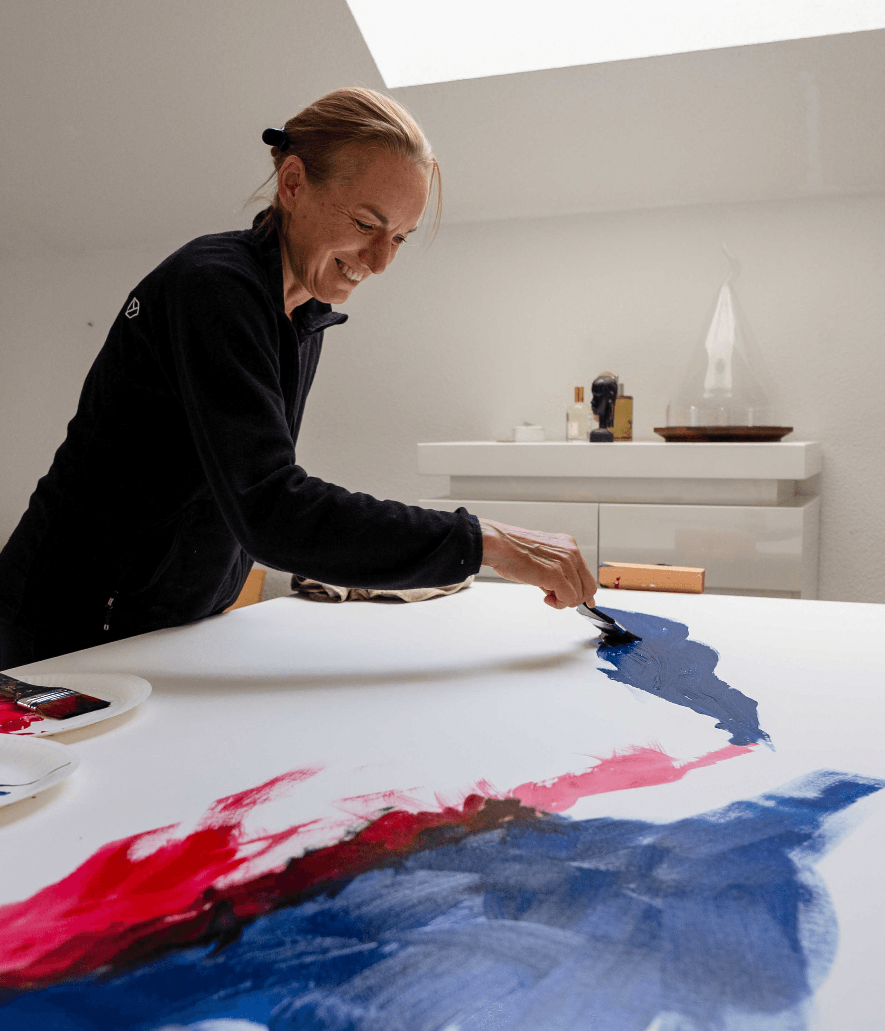 Künstlerhand arbeitet an abstraktem Gemälde auf Leinwand im Atelier