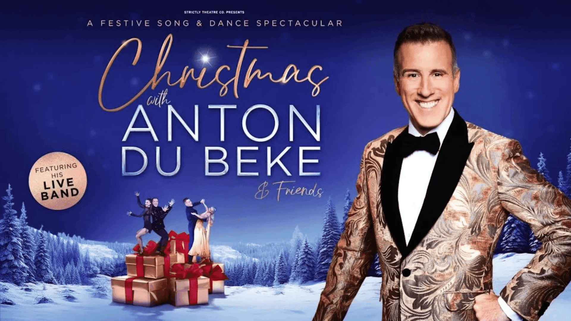 Christmas event with Anton Du Beke and dancers on gift boxes in snowy landscape.