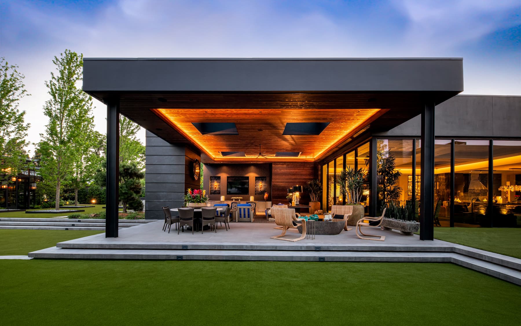 Outdoor living design featuring multiple seating areas and landscape lighting design for Dallas estate. 