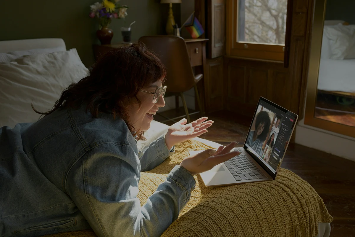 A woman speaking and gesturing during a laptop video call.
