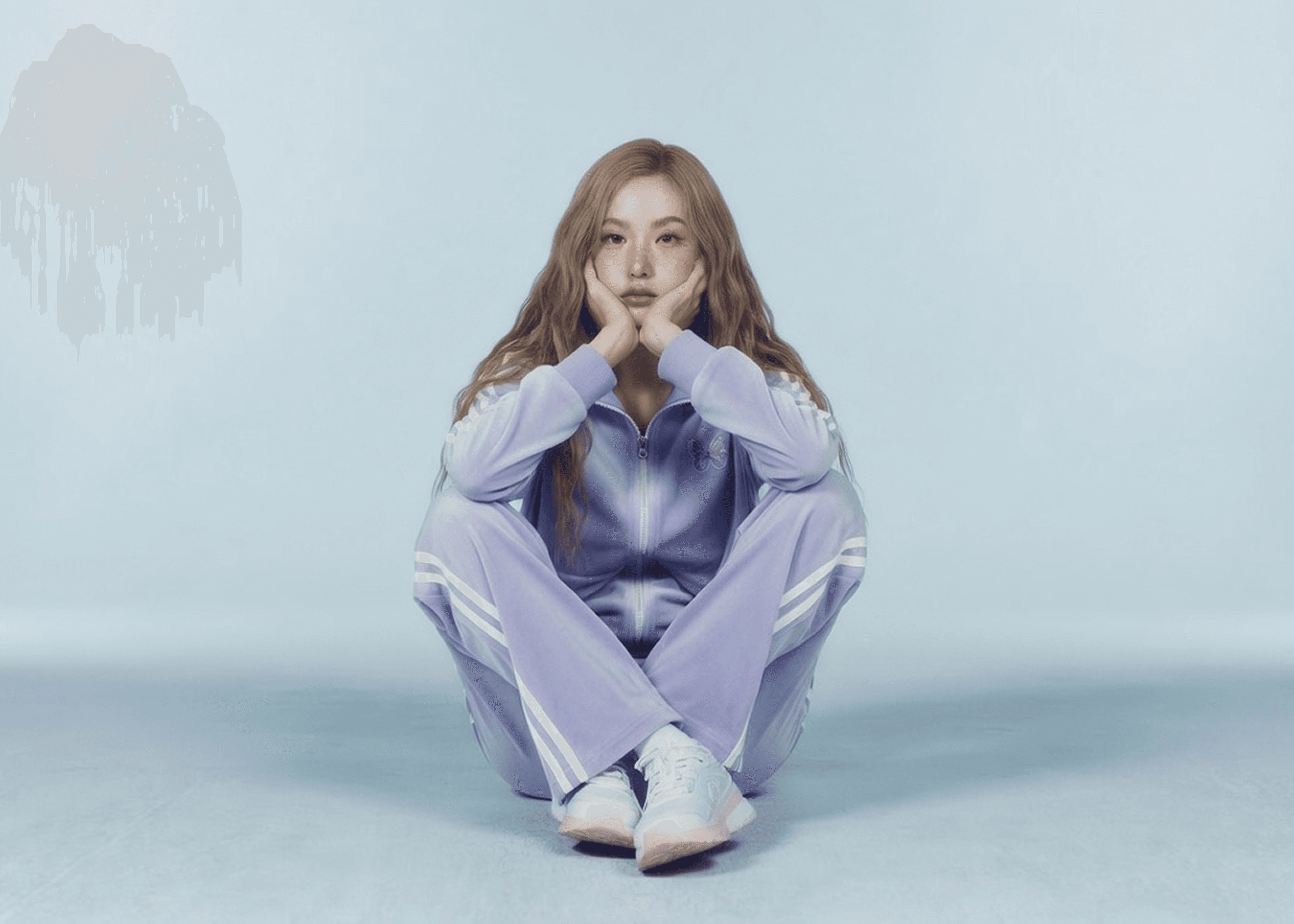 Woman in a purple tracksuit sitting on the floor against a blue background