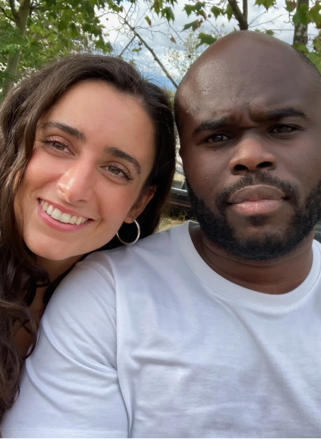 A bride and groom share a kiss, enveloped in the bride's flowing veil. The soft focus and gentle light convey a romantic, intimate atmosphere.