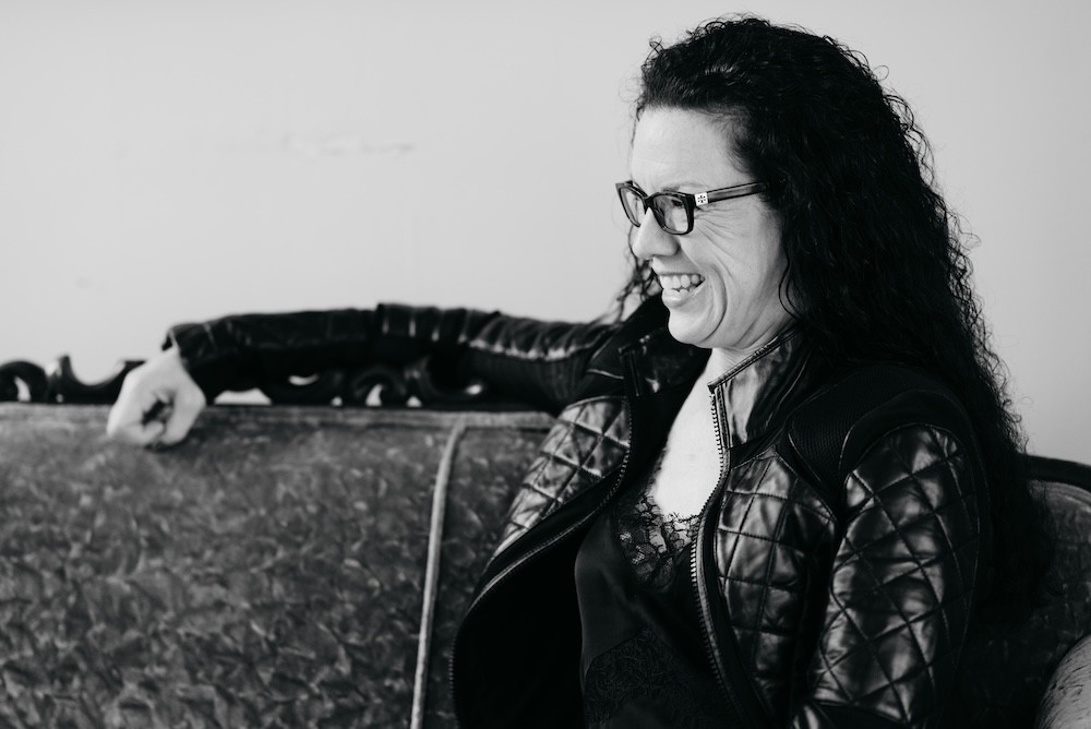 Coleen smiling on a couch