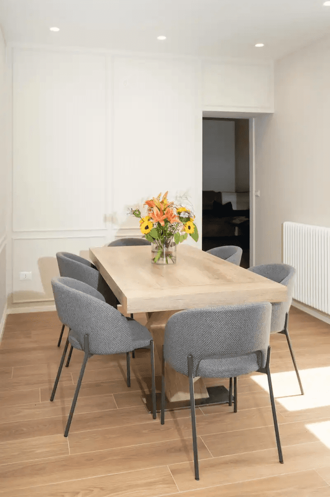 sala con parquet e tavolo in legno illuminata dal sole