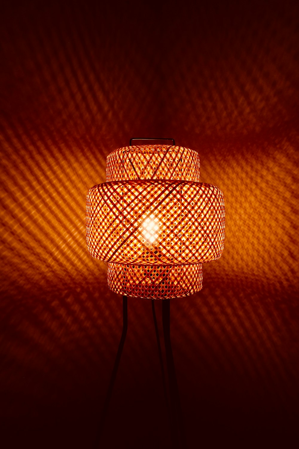 Woven wall lamp casting patterned light