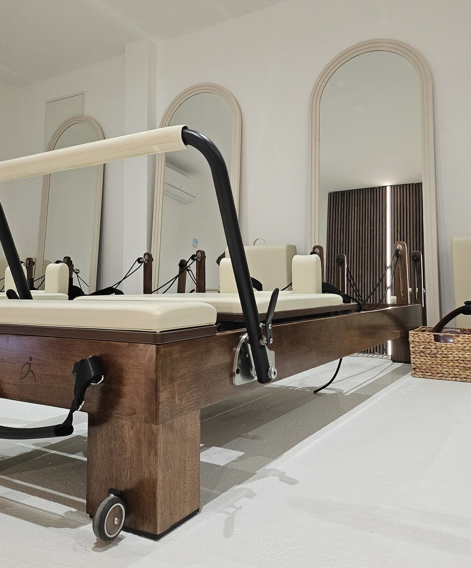 Appareil Pilates Reformer en bois, studio lumineux avec miroirs et accessoires