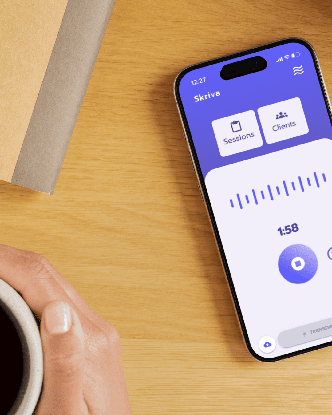 A phone with Skriva on it and a person holding a cup of coffee