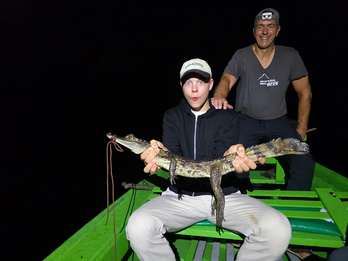 Zwei Männer im Boot mit einem gefangenen Alligator