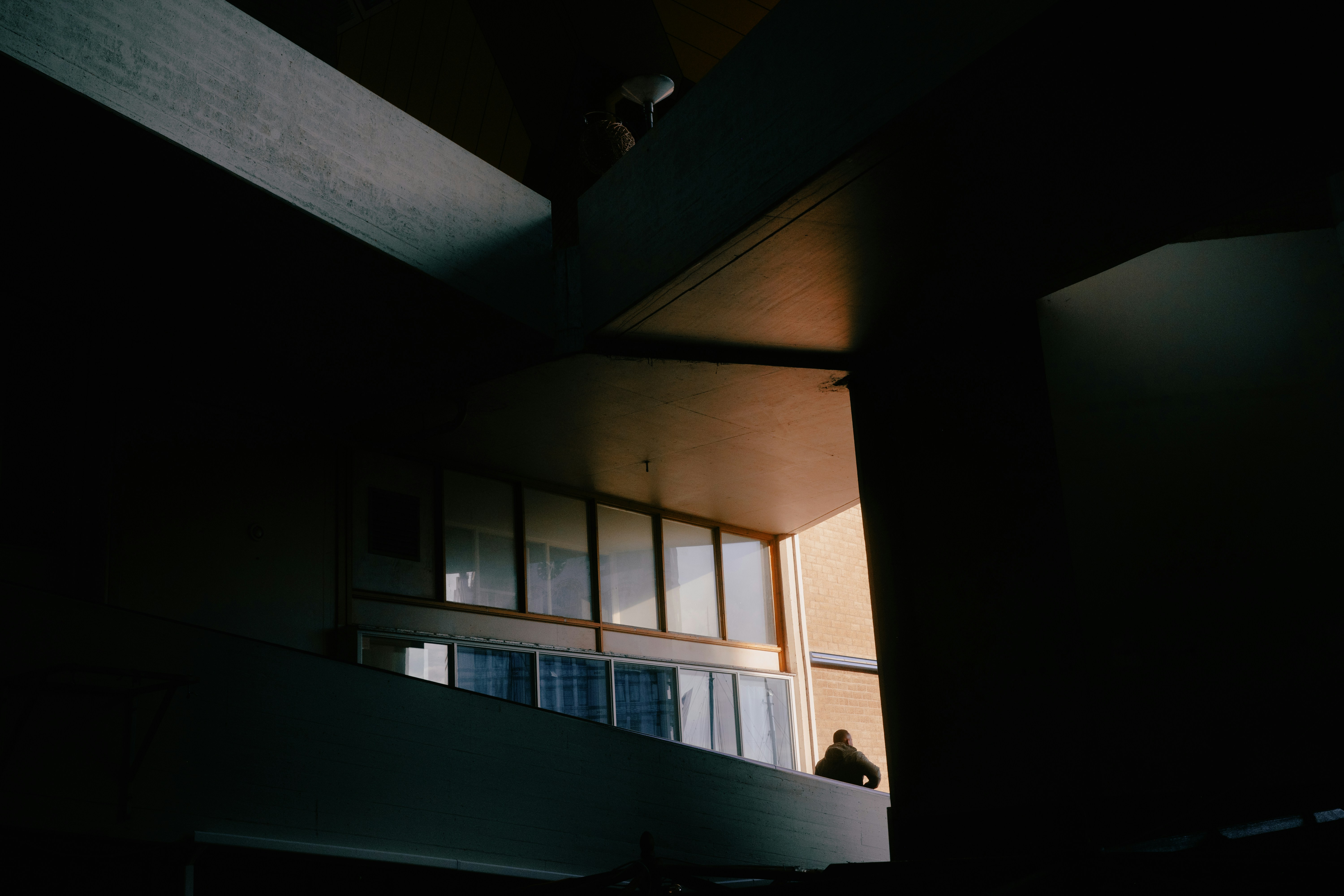 A dark room with a person standing in the window