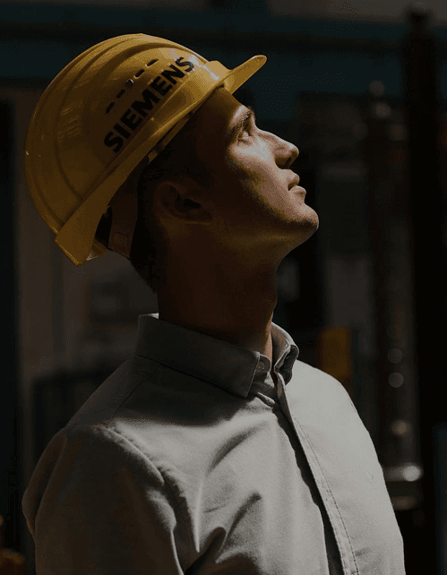 Male engineer in uniform and hard hat with arms crossed