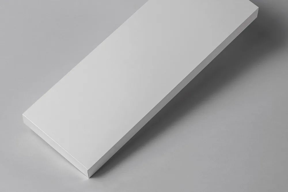 Rectangular box mockup with bold red and black typography on a light beige surface. The sleek design emphasizes modern branding, with subtle embossed text and clean shadows enhancing the minimal aesthetic.
