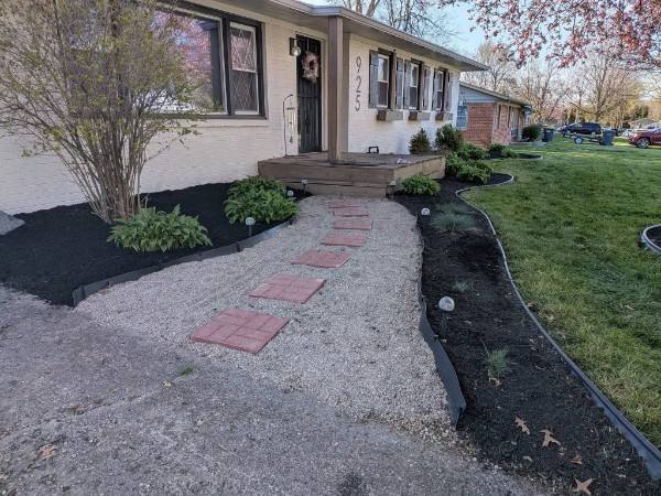 Landscaped front walkway with paver stepping stones and freshly mulched beds at a home in Anderson, Indiana